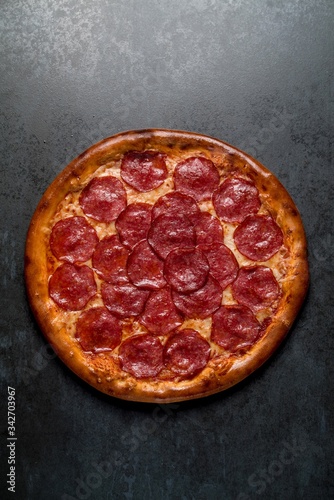 Italian pizza with pepperoni cheese and sauce on black background
