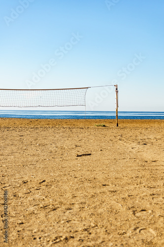 Volleyball net on sandy beach.