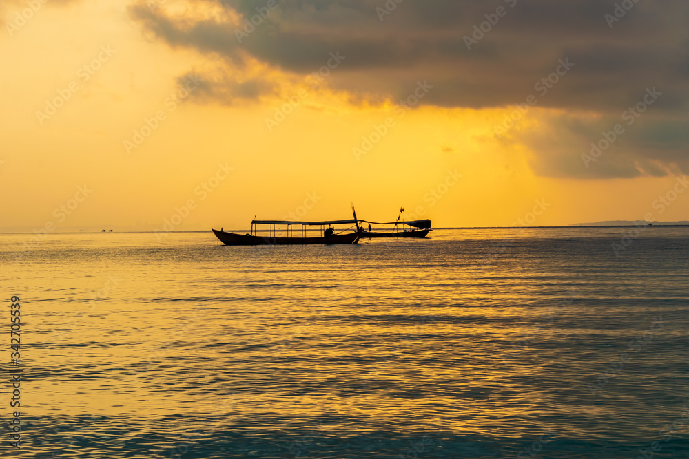 A boat in the sea with the sunset background at Koh Ta Kiev, Cambodia A boat in the sea with the sunset background at Koh Ta Kiev, Cambodia
