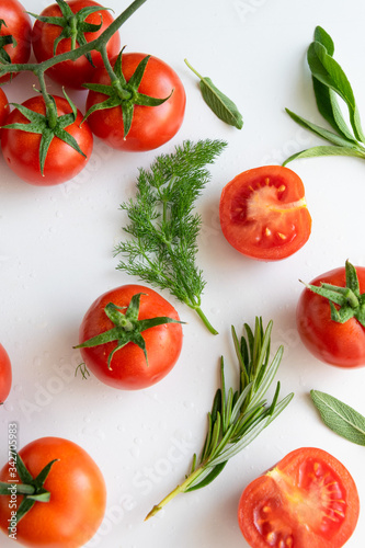 Healthy food background - raw tomatoes and wild herbs on white background, vibrant colours, vitamin food © 682A_IA