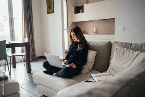 Giovane bella ragazza studente/ lavoratrice studia/ lavora da casa con il computer. Smart working e distanza sociale. Lavorare con la tecnologia 