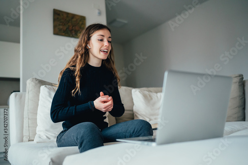 Giovane bella ragazza studente/ lavoratrice studia/ lavora da casa con il computer. Smart working e distanza sociale. Lavorare con la tecnologia 