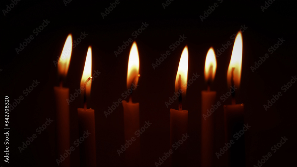 Several lit candle with dark empty background . Landscape layout. Several lit candle with dark empty background . Landscape layout.