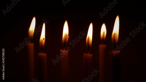 Several lit candle with dark empty background . Landscape layout. 