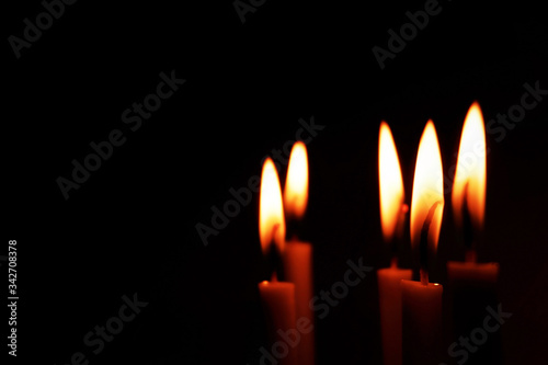 Several lit candle with dark empty background . Landscape layout. 