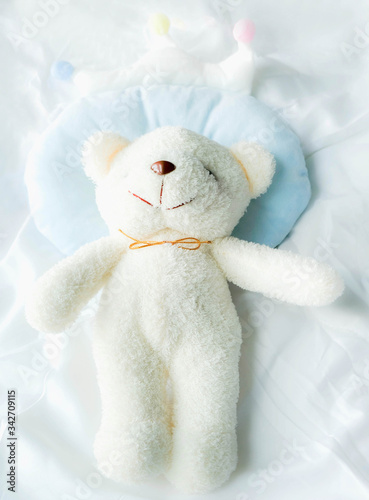 Top view a white bear lying on bed