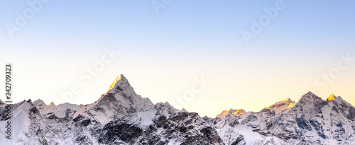 Himalayan mountain range. Banner sized photo with Ama Dablam peak and blue sky. photo