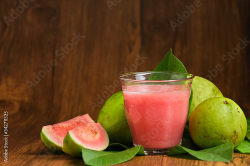 guava juice is served on a wooden background