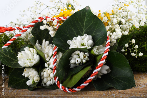 Spring time flowers like snowdrops, flat lay, isolated on colored simple background, spring symbol and traditional Romanian 