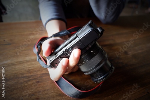 A Man Holding a Camera on the Table

