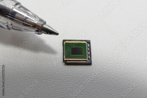 Smartphone camera image sensor compared to the tip of a pen

