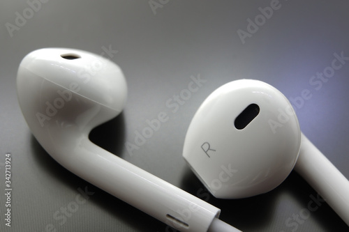 White earphone earbud type and with black reflective background
