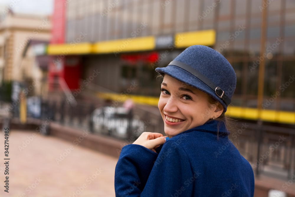 Stylish young lady on the street walks in spring in blue coat and cap. Stylish young lady on the street walks in spring in blue coat and cap.