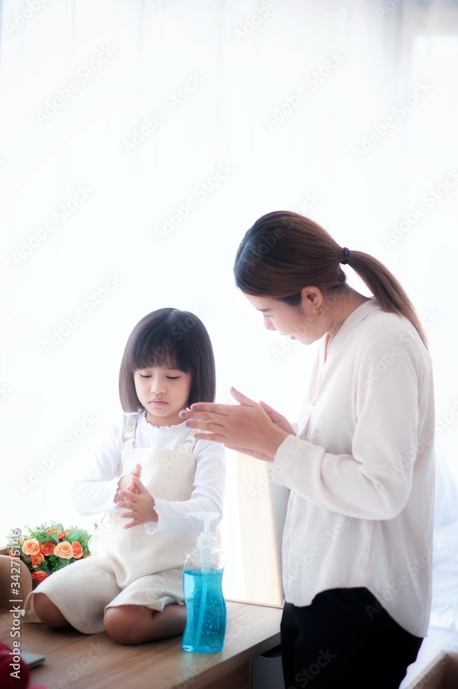 Mother is teaching daughter wash hands with alcohol gel. To kill corona virus in the bedroom Mother is teaching daughter wash hands with alcohol gel. To kill corona virus in the bedroom