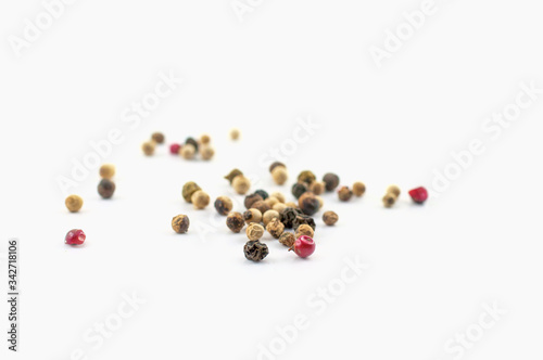 Red, green and black peppercorns or balls mixed isolated on a white background.