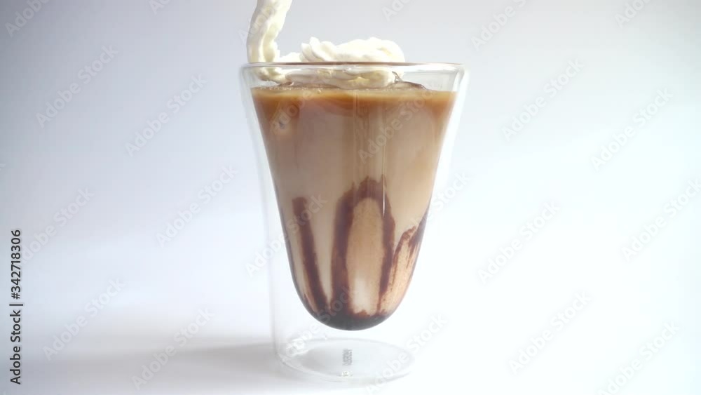 Preparation of coffee drink from ice, milk, coffee, cream and chocolate topping. Slow motion. Preparation of coffee drink from ice, milk, coffee, cream and chocolate topping. Slow motion.
