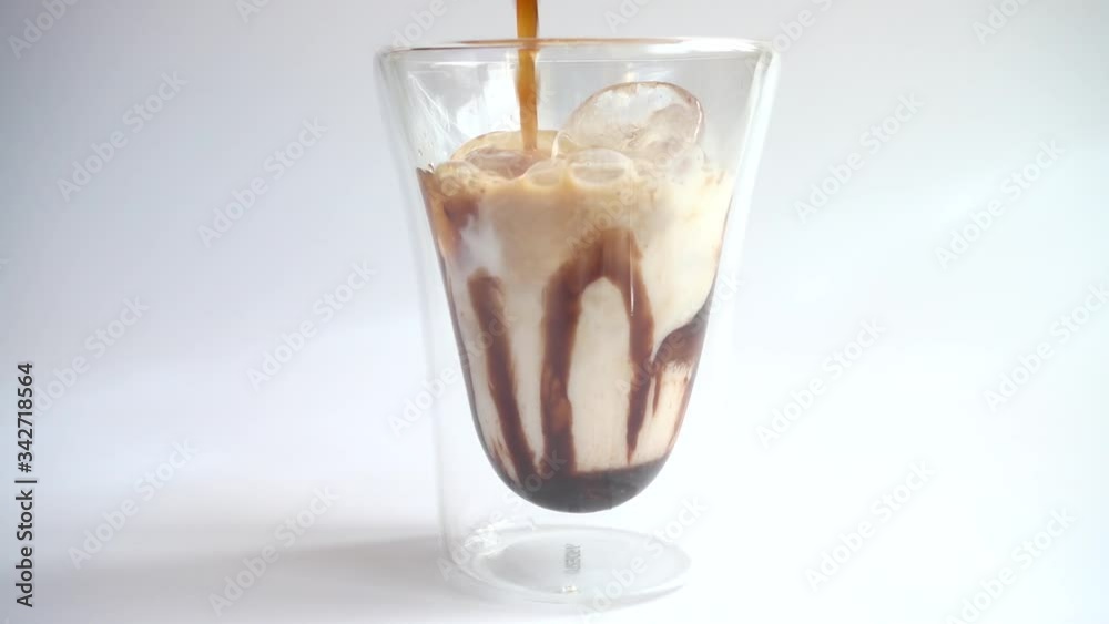 Preparation of coffee drink from ice, milk, coffee and chocolate topping. Slow motion. Preparation of coffee drink from ice, milk, coffee and chocolate topping. Slow motion.