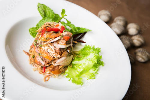 thai herb spicy clams salad serve in white plate