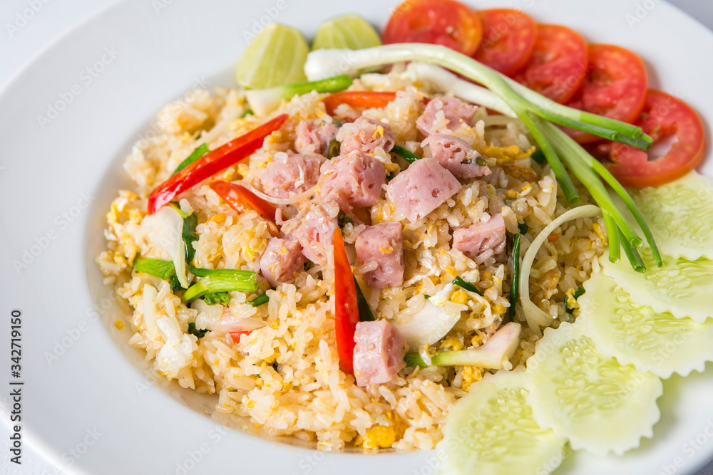 thai fired rice with sour pork decorated with sliced cucumber and tomato