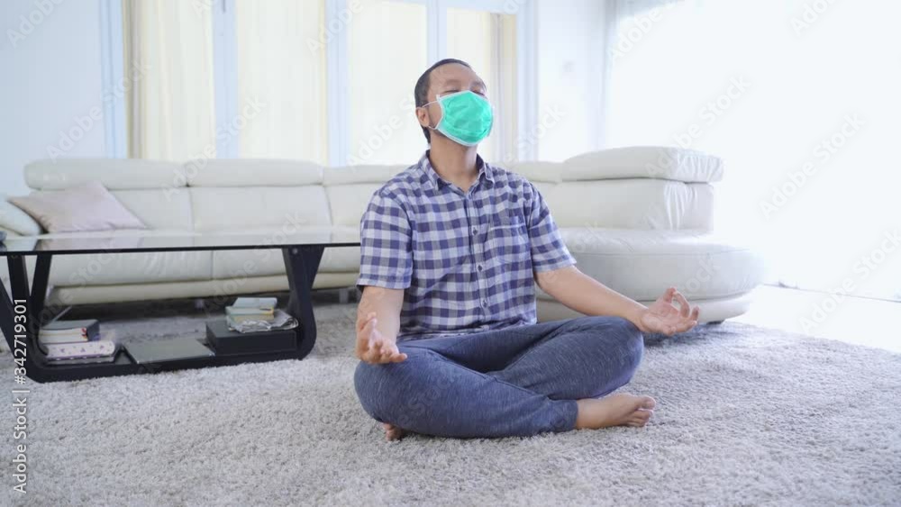 Asian man wears face mask while exercising yoga Asian man wears face mask while exercising yoga