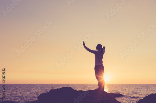 Belief concept Woman raising hands to pray for blessings During the sunset image Vintage style