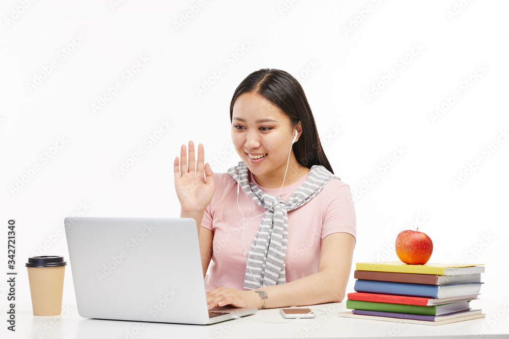 Asian student works attentively on her laptop. Asian student works attentively on her laptop.