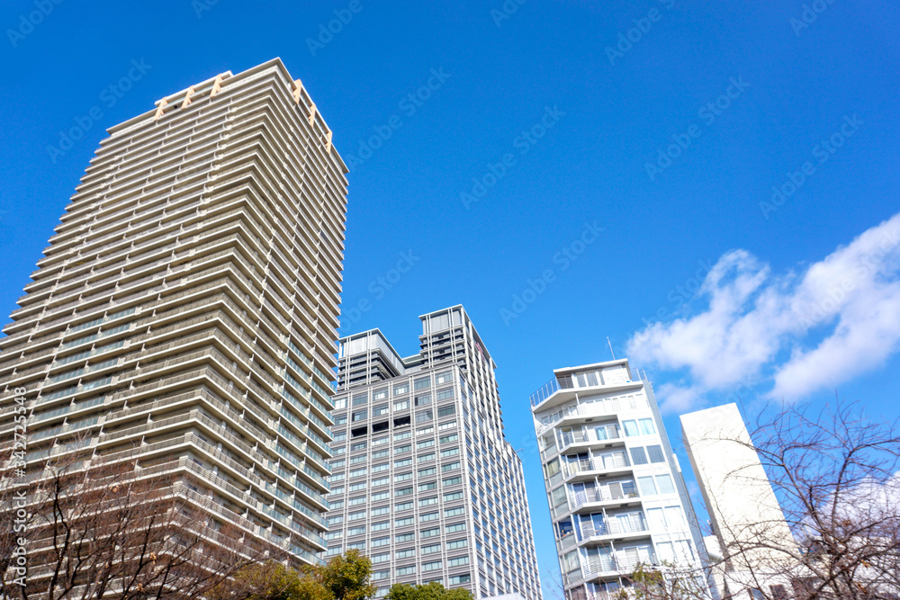 Osaka, Japan-January 18, 2019 : Landscape of city building on bright blue sky with clouds background. Osaka, Japan-January 18, 2019 : Landscape of city building on bright blue sky with clouds background.