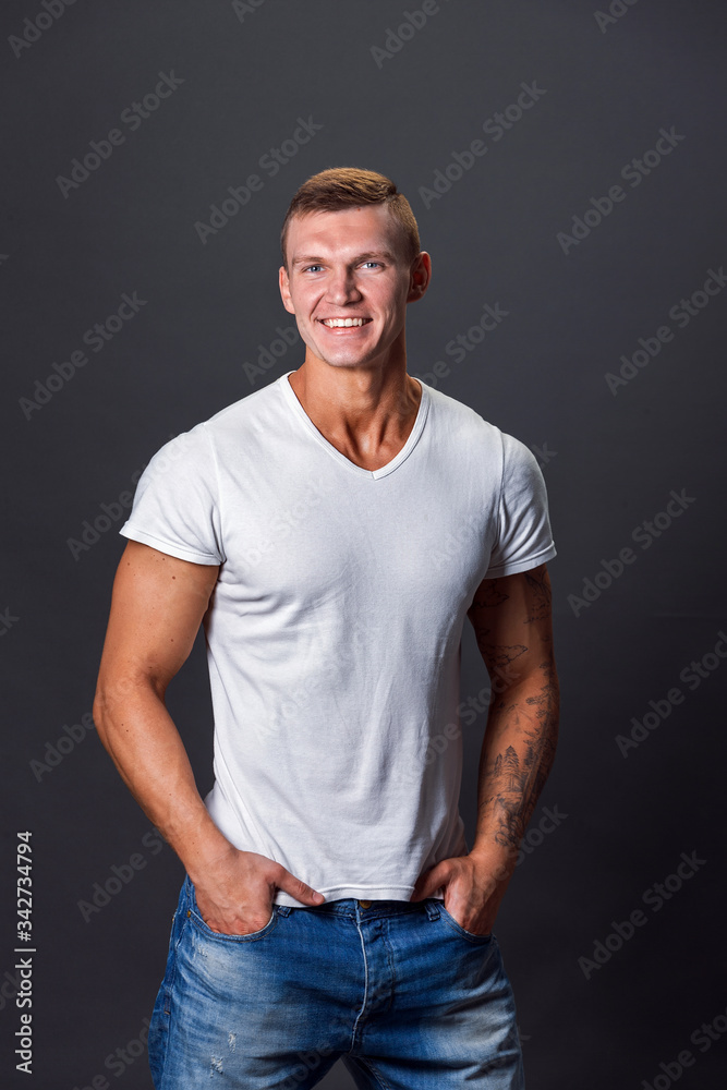 Smiling man in blank t-shirt, gray background. Smiling man in blank t-shirt, gray background.