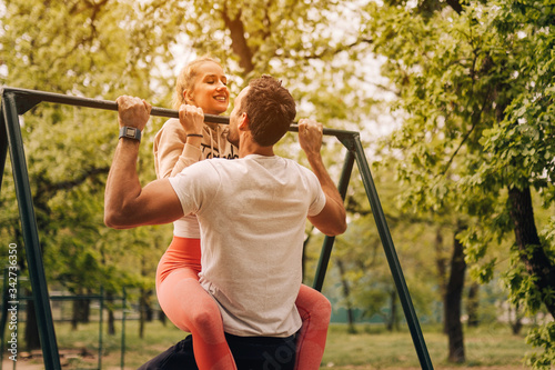 Couple in love doing chin ups in park