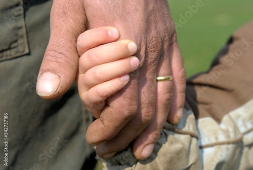 Agriculteur tenant son jeune fils par la main photo