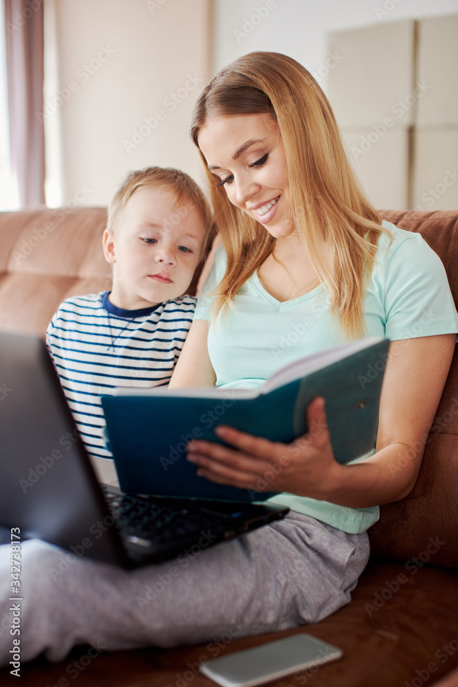 Mother and son drawing in notepad while using laptop Mother and son drawing in notepad while using laptop