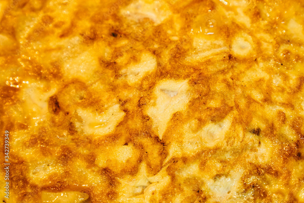 Background of an appetizing Spanish tortilla. Texture and details of an omelette with eggs, potatoes and onions. Background of an appetizing Spanish tortilla. Texture and details of an omelette with eggs, potatoes and onions.
