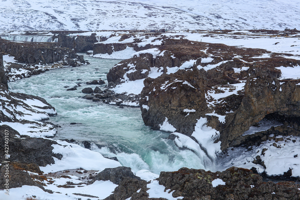 Quick boiling river in Iceland, among the rocks and snow Quick boiling river in Iceland, among the rocks and snow
