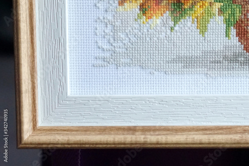 cross stitch corner on the canvas, framed