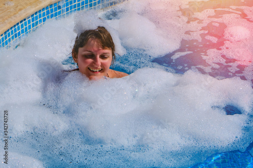 Lots of foam bubbles around the girl in the pool