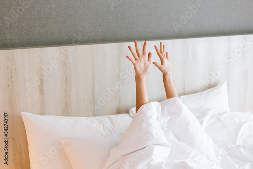 Foto Capture of female arm stretching while waking  up on bed.