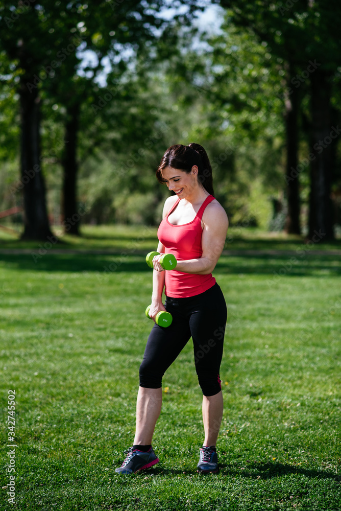 Young athletic fitness woman working out at the park. Lifestyle