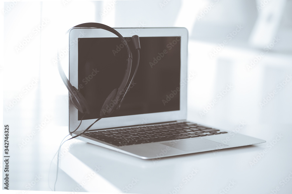 Call center and communication support, customer service help desk. VOIP headset on laptop computer Call center and communication support, customer service help desk. VOIP headset on laptop computer