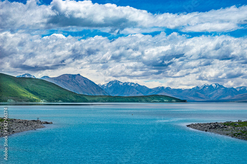 Lake landscape with mountains under cloudy sky