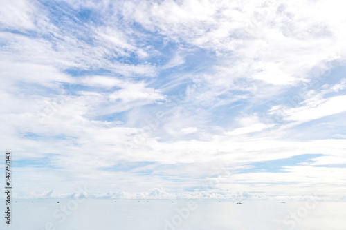 Cloudy white sky and white sea with little black spots of fisherman ships
