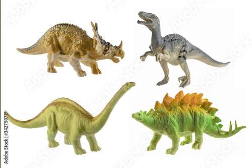 Four toy rubber dinosaurs isolated on white