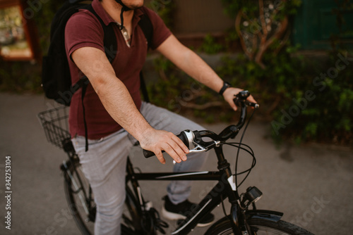 Young caucasian cyclist with helmet and sunglasses on a bicycle in front of the window