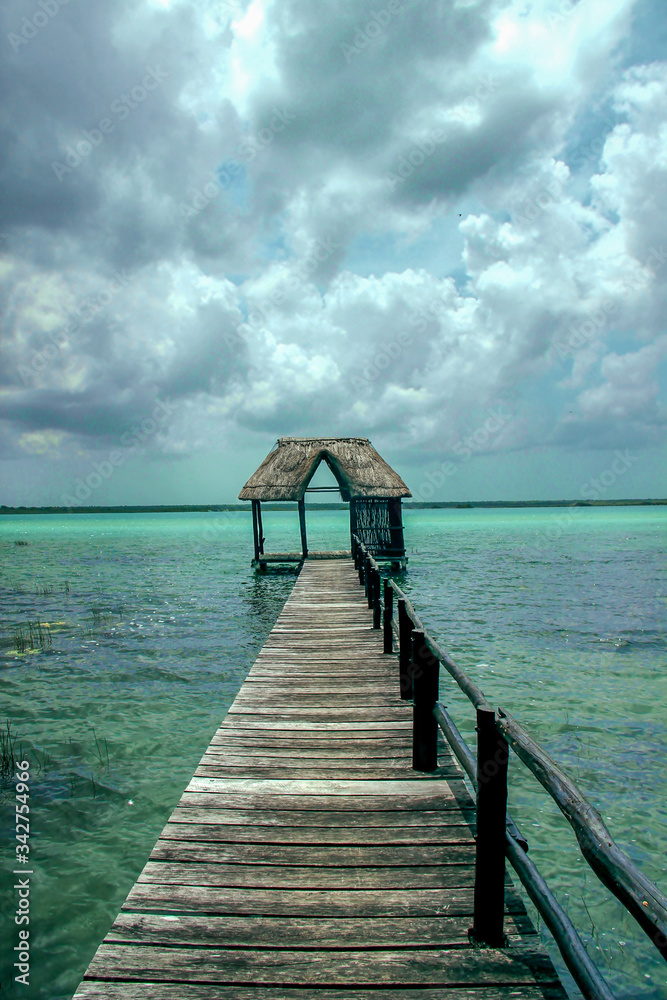 Fototapeta premium Thatched hut on the end of a pier in paradise