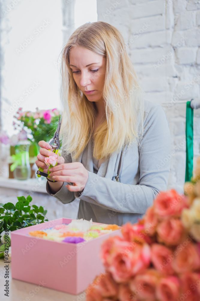 Portrait of professional woman floral artist, florist making gift box with flowers at workshop, flower shop. Floristry, holiday, birthday, handmade and small business concept Portrait of professional woman floral artist, florist making gift box with flowers at workshop, flower shop. Floristry, holiday, birthday, handmade and small business concept
