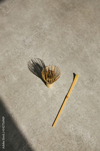 Bamboo whisk and chashaku bamboo spoon for matcha tea on a gray background.