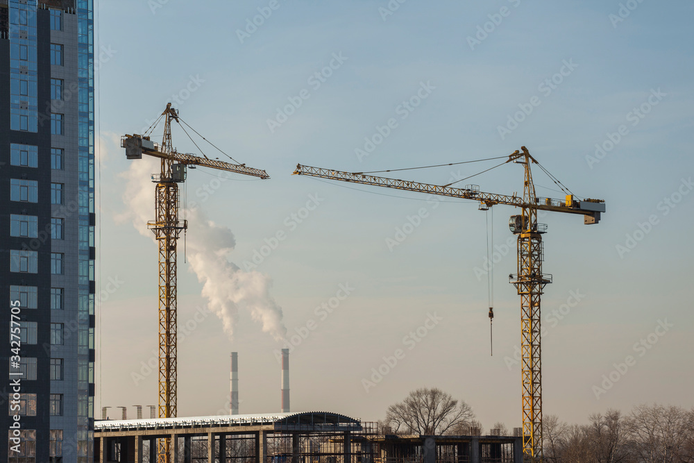 construction site with cranes against the blue sky construction site with cranes against the blue sky