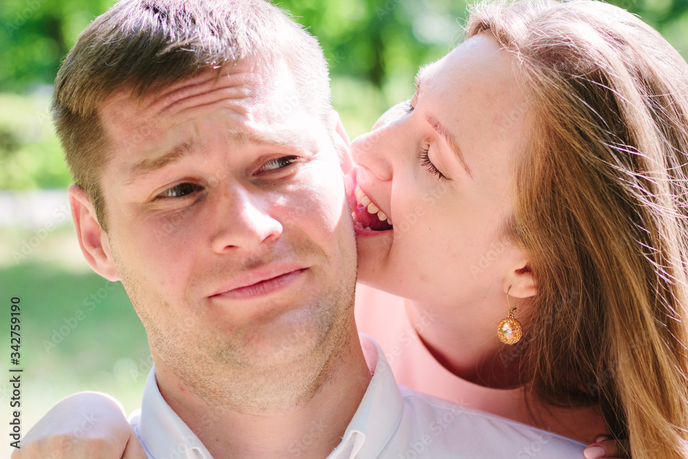 Young couple - girl bites guy to an ear Young couple - girl bites guy to an ear