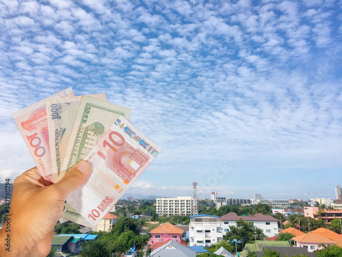 Many currency bangknote in hand with blue sky background photo