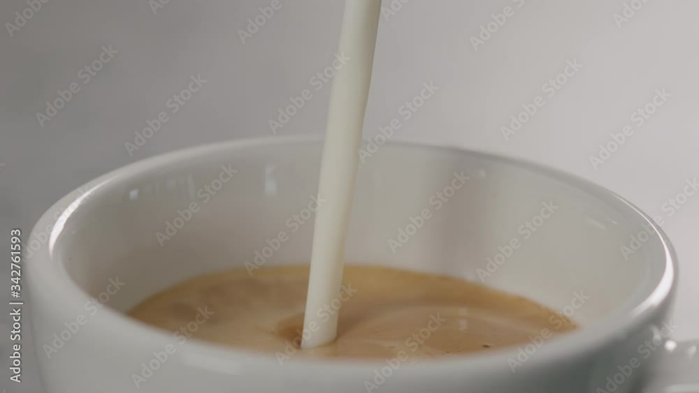 slow motion closeup steamed milk pour into white cup to make cappuccino slow motion closeup steamed milk pour into white cup to make cappuccino