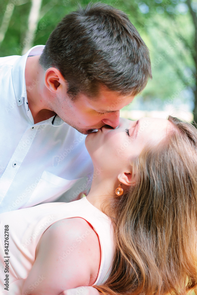 Young couple - girl and guy kissing at the park Young couple - girl and guy kissing at the park